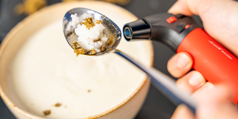 Nimm nun ein Feuerzeug und erhitze (vorsichtig) die Unterseite des Löffels.